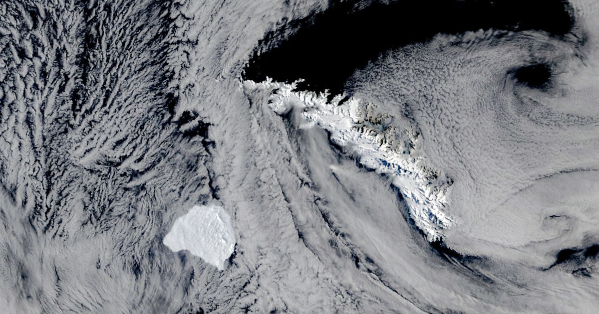 NASA satellite view of iceberg A-81, a white slab among clouds, near snow-covered South Georgia